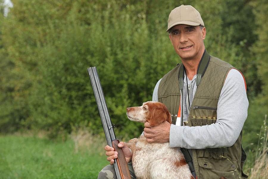 hunter with a rifle and a dog