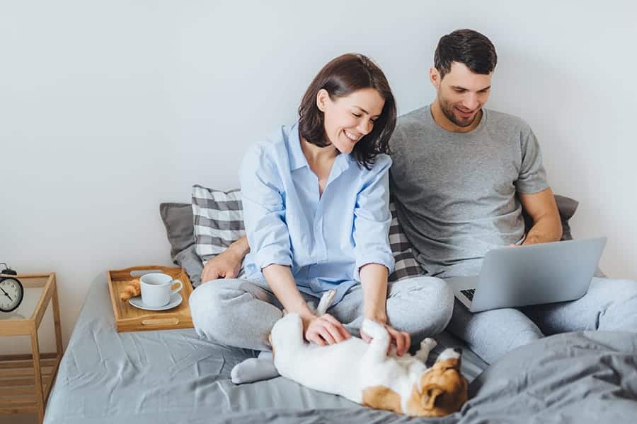 a dog on a bed with family and coffee cup